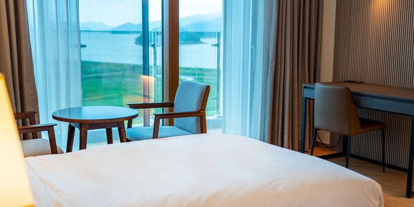 Una habitación de hotel con cama, escritorio, silla y mesa.