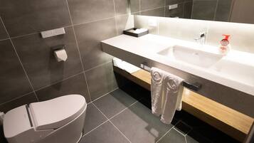 Ein modernes Badezimmer mit Toilette, Waschbecken und Handtuchhalter.