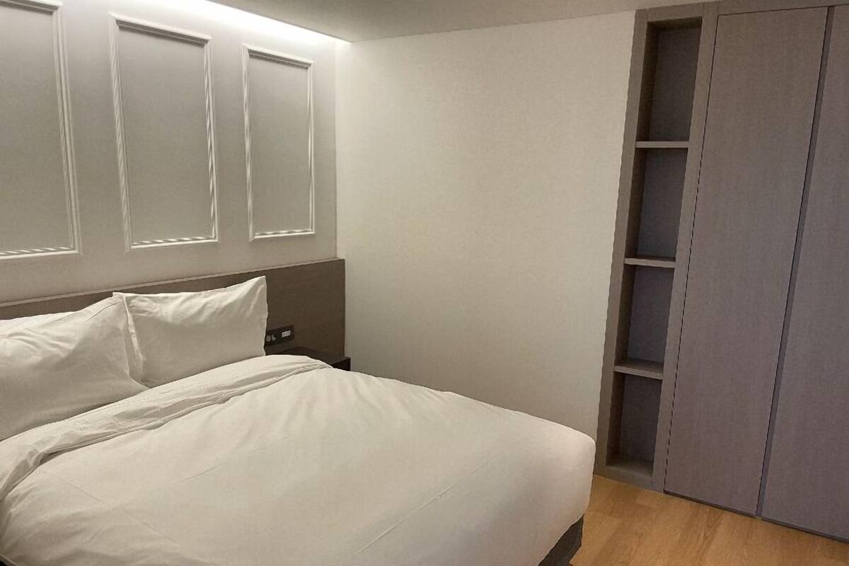Un dormitorio con cama, mesita de noche y armario empotrado.