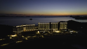 Un grand hôtel à plusieurs étages, avec vue sur le port, qui se distingue par son entrée imposante et sa façade bien éclairée.