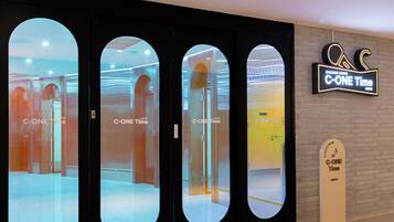 Ein Hotel Eingang mit drei Glasüren, auf jeder steht 'C-ONE Time'.
