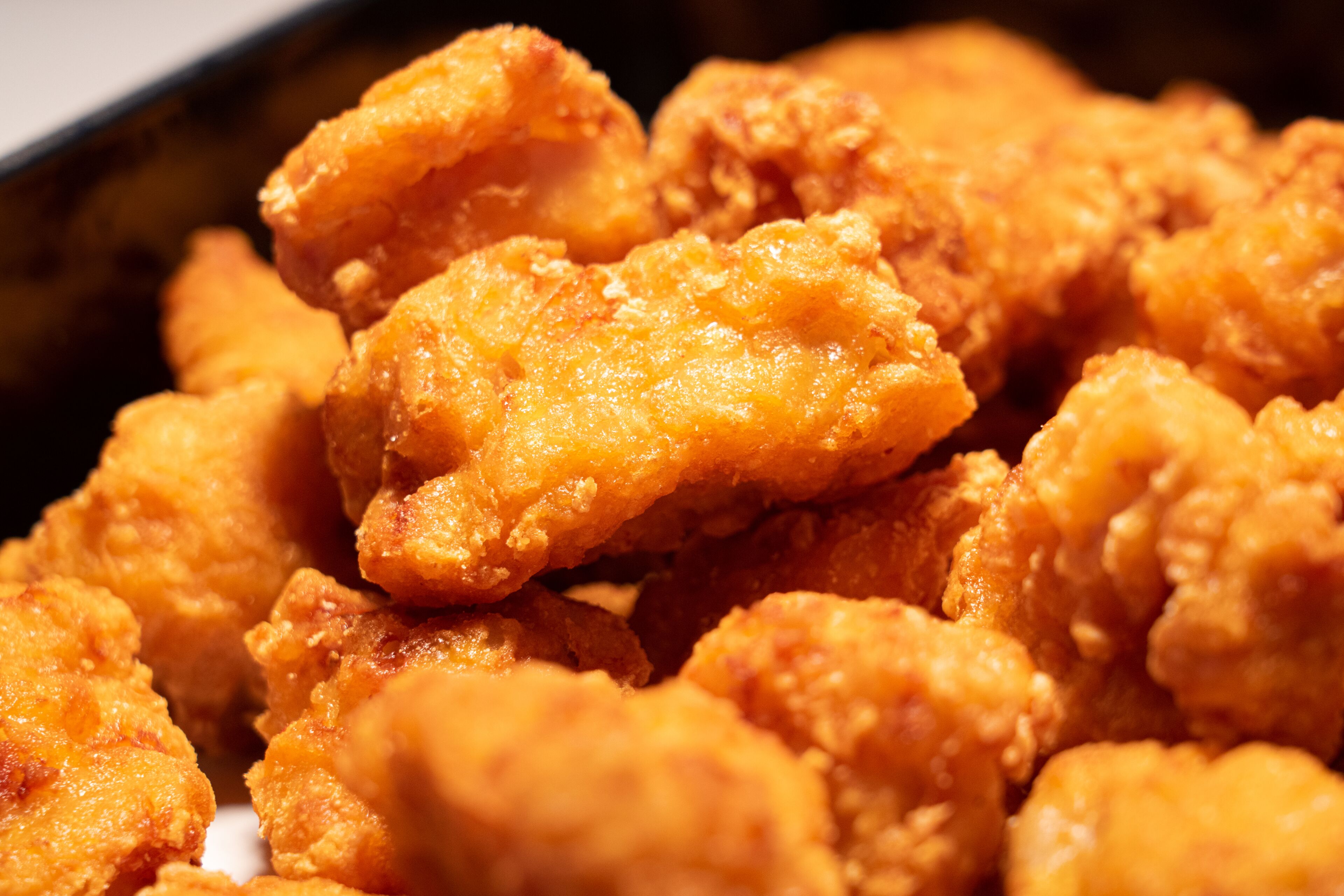 A close-up of golden-brown fried chicken pieces.