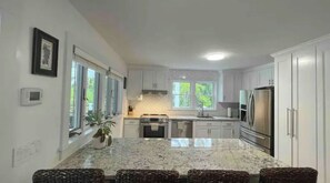 Enjoy meals in the well-lit kitchen with a dining area and views of the surrounding greenery.