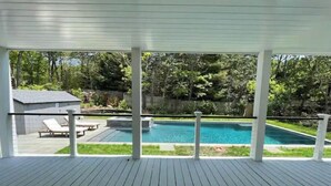 Una terrazza coperta con piscina, sedie a sdraio e un piccolo deposito.
