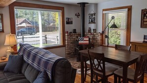 Ein gemütliches Wohnzimmer mit Kamin, einem Esstisch und einer Couch.