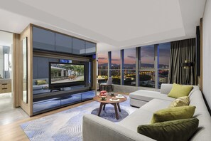 A modern living room with a large TV, a sofa, a coffee table, and a city view. - Somerset Suzhou Bay Suzhou (Suzhou)