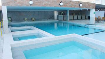 Une piscine avec plusieurs couloirs, un espace d’accueil et un mur en briques.