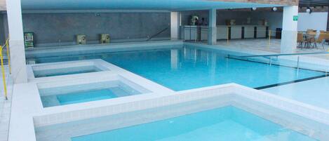 Una piscina con diverse corsie, un'area reception e un muro in mattoni.