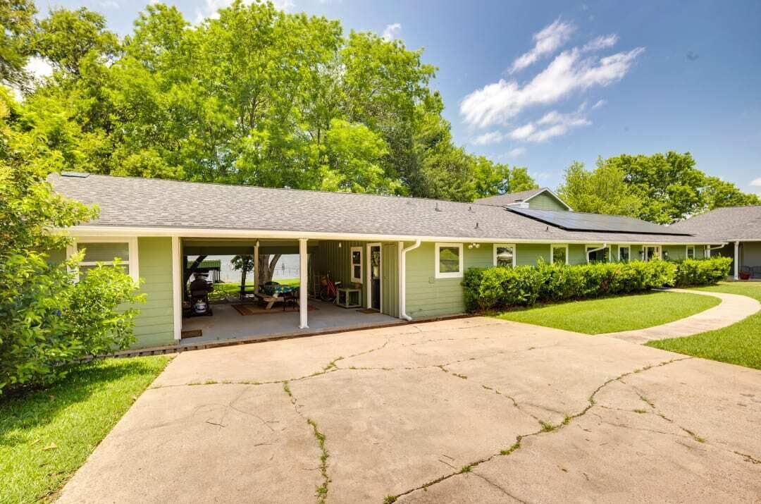 Ein eingeschossiges Haus mit Veranda, Garage und Auffahrt zur Haustür.