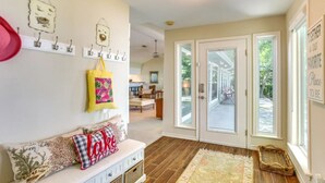A spacious entryway with a bench, a decorative wall with hooks, and a large window. - Family Friendly Lakefront Luxury, Private Water trampoline, arcade, BYOB boat (Livingston)