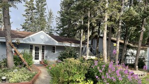 Una casa con jardín, una hamaca y una escalera de madera.