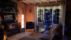 Un salón acogedor con chimenea, un árbol de Navidad y un sofá cómodo.