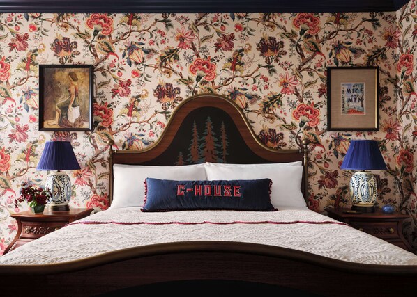 A bed with a floral wallpaper, a framed picture on the wall, and a lamp on each side. - Graduate by Hilton Palo Alto (Palo Alto)