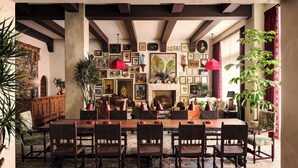 A dining area with a large wooden table, multiple chairs, and a patterned floor. - Graduate by Hilton Palo Alto (Palo Alto)