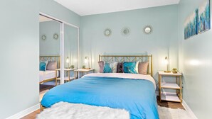 Una camera da letto con un letto, comodini, uno specchio e opere d'arte alle pareti.
