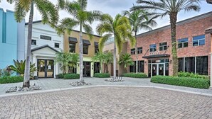 Un patio con sendero de ladrillo, palmeras y edificios que incluyen un gimnasio.