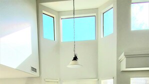 Un comedor espacioso con techo alto, ventanas amplias y vistas al exterior.