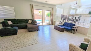 Un salón espacioso con un sofá modular, una mesita y una alfombra estampada.