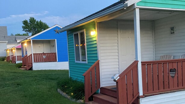 A row of mobile homes with individual porches and steps leading to the entrance. - The Green Cottage@ Twin Hills Cottages (Ellsworth)