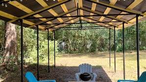 A covered outdoor seating area with a table and chairs, surrounded by trees. - NEW! 19 Minutes from Savannah Historic District (Bloomingdale)
