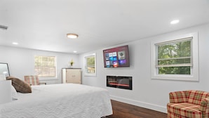 A bedroom with a bed, a TV mounted on the wall, a fireplace, and a window. - NEW! 19 Minutes from Savannah Historic District (Bloomingdale)