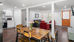A modern kitchen with white cabinets, a microwave, and a dining area with a wooden table and chairs. - NEW! 19 Minutes from Savannah Historic District (Bloomingdale)