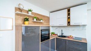 Een moderne keuken met donkere kastjes, een houten aanrechtblad en een ingebouwde oven.