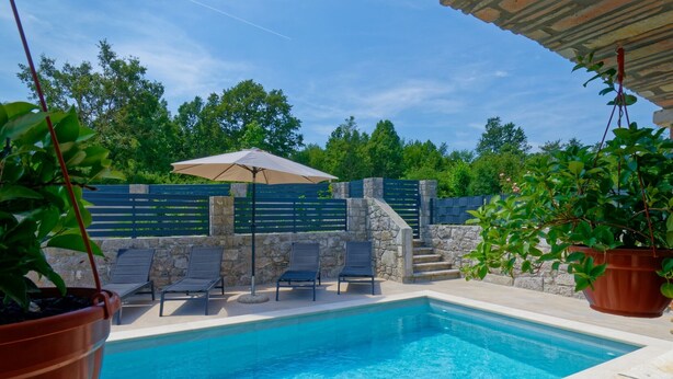 Une piscine avec des chaises longues et une pergola.