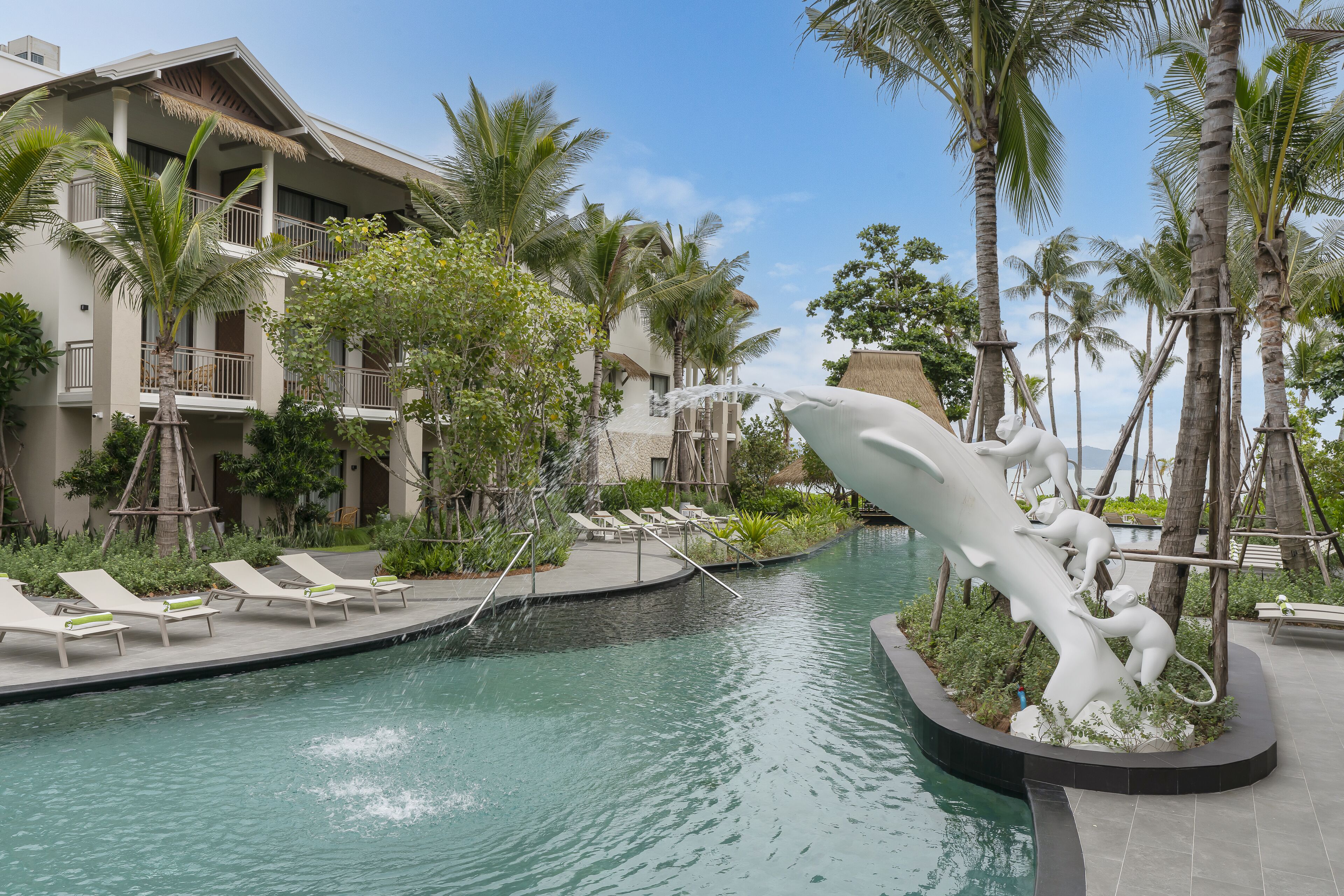 A swimming pool with lounge chairs and a decorative sculpture.
