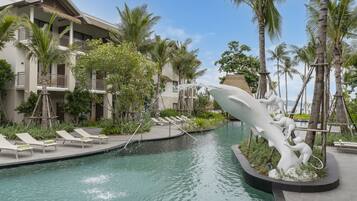 A swimming pool with lounge chairs and a decorative sculpture.