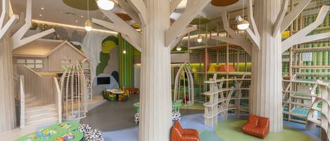 A children's play area with tree-like structures, seating, and climbing elements.