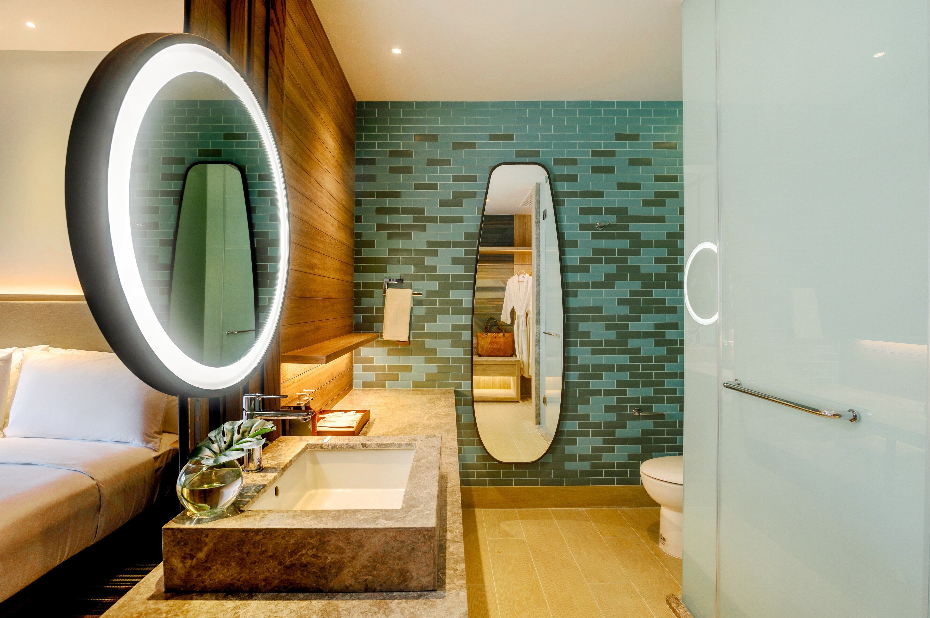 A modern bathroom with a large mirror, a sink, and a toilet.