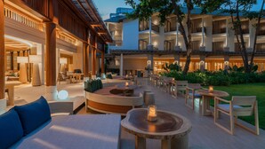 A hotel courtyard with outdoor seating, a pool, and a well-lit building facade. - Holiday Inn Resort Samui Bophut Beach by IHG (Koh Samui)