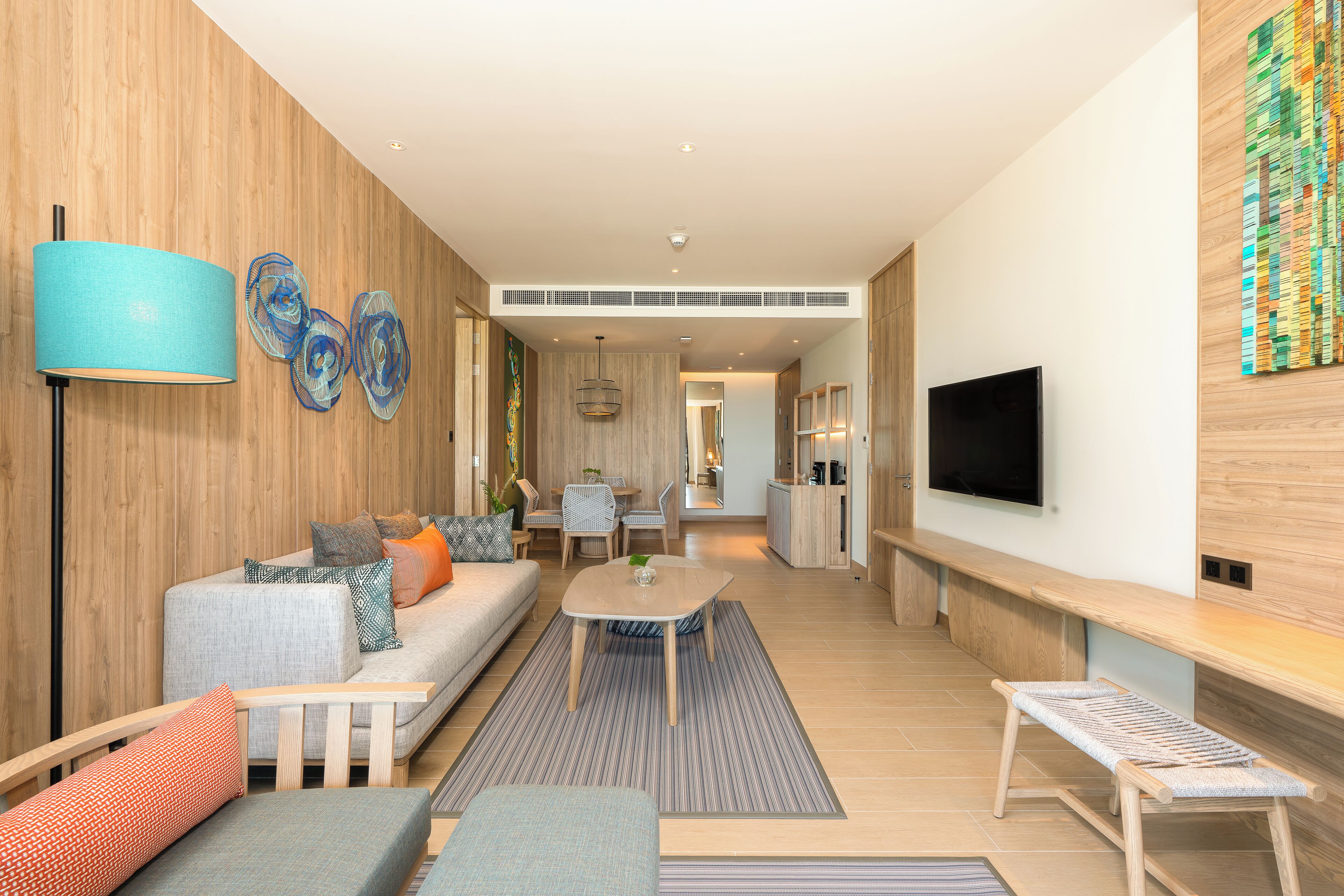 A modern living room with a sofa, coffee table, and a TV mounted on the wall.