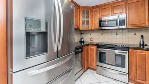A kitchen with stainless steel appliances, wooden cabinets, and a tiled backsplash. - Beautiful 2/2.5 Condo w/Free Parking Fast WIFI (Miami)