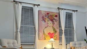Una sala de estar con dos sofás, una mesita auxiliar y un cuadro.