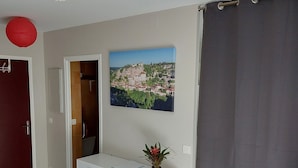 Ein Zimmer mit einem weißen Schrank, einer roten Tür, einem Stadtbild und einem grauen Vorhang.