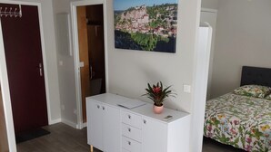 Ein Schlafzimmer mit einem Bett, einem Schminktisch, einem Schreibtisch und einem Stuhl.