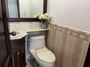 Un baño con inodoro, lavabo y espejo.