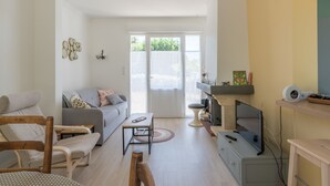 Un soggiorno moderno con un divano, poltrone, televisione e zona pranzo.