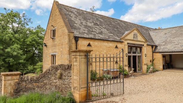 A stone building with a gated entrance, a stone staircase, and a gravel driveway. - Rookery Hall (Broadway)