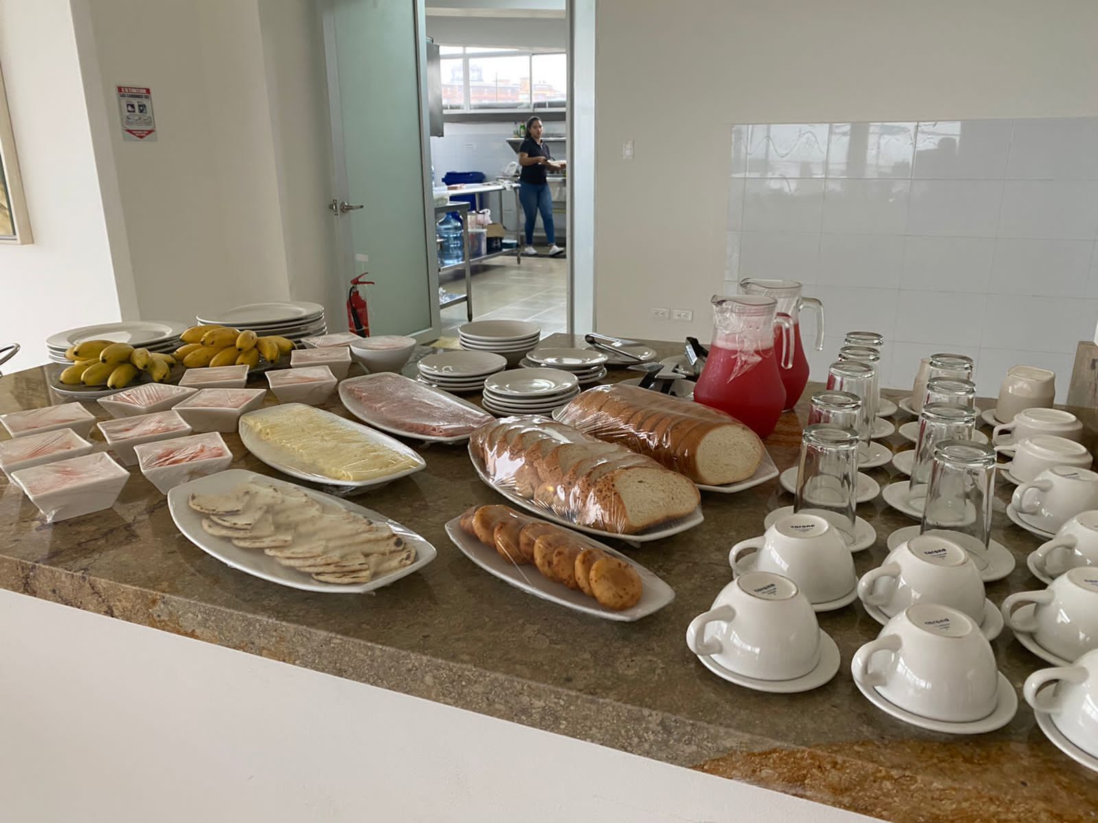 Een overvloedig buffet met diverse gerechten en drankjes op een marmeren aanrecht.
