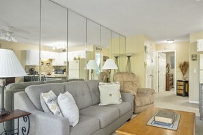 A living room with a grey sofa, a wooden coffee table, and a beige armchair.