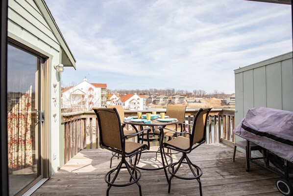 Une terrasse avec une table et des chaises, donnant sur un quartier résidentiel.