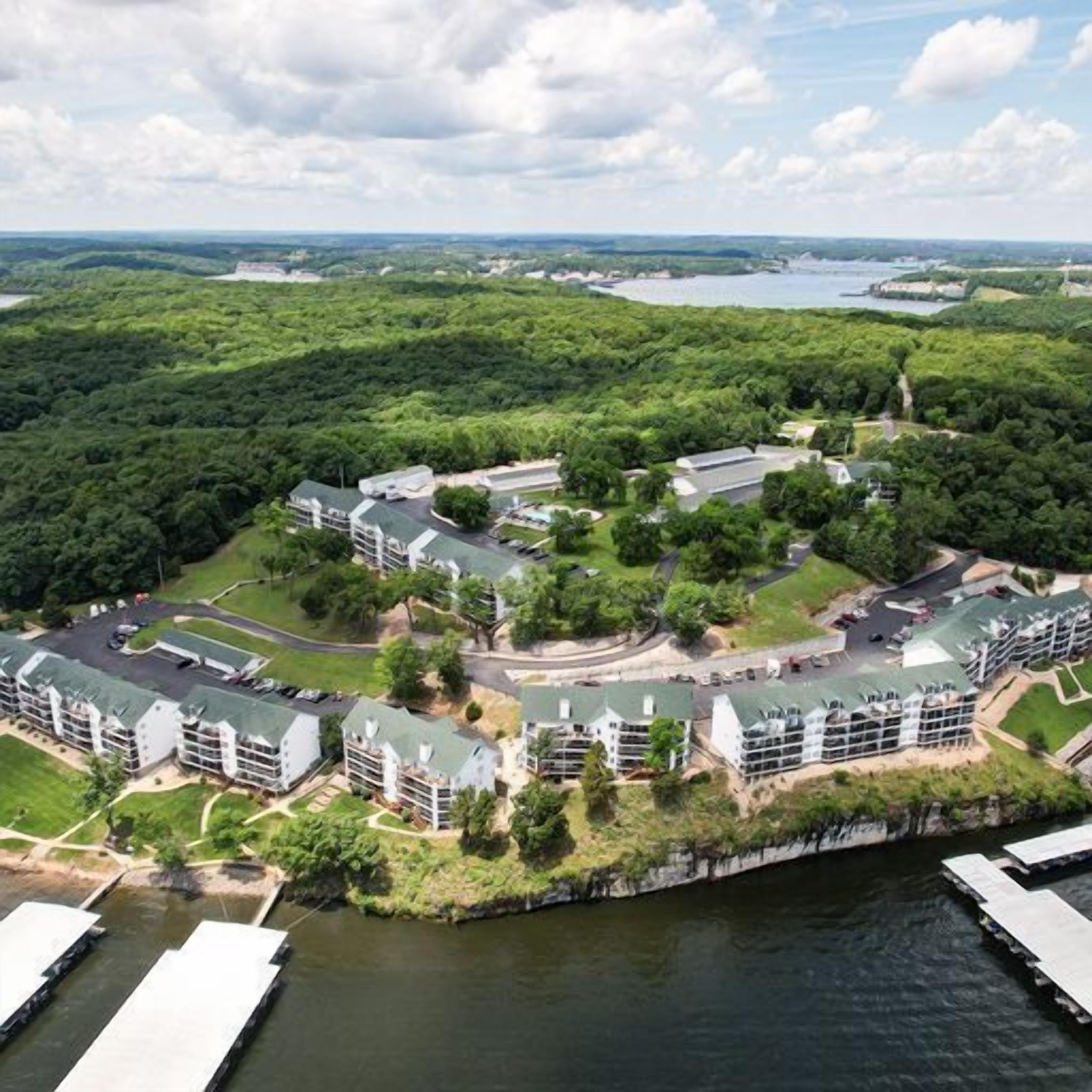 A resort with multiple buildings, a dock, and a lake.