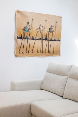 Relax in a serene space with a stylish sofa and a unique piece of wall art.