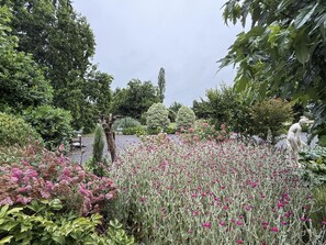 A garden with various plants and a statue.