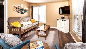 A living room with a sofa, armchairs, a coffee table, and a TV. - ⁂Centrally Located⁂Close to Downtown⁂Stocked Kitchen⁂ (Rapid City)