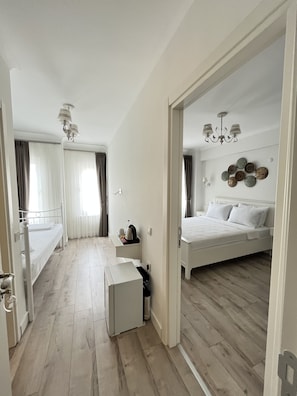 Quarto triplo luxo, 2 quartos | Frigobar (abastecido com alguns itens grátis), individualmente decorados