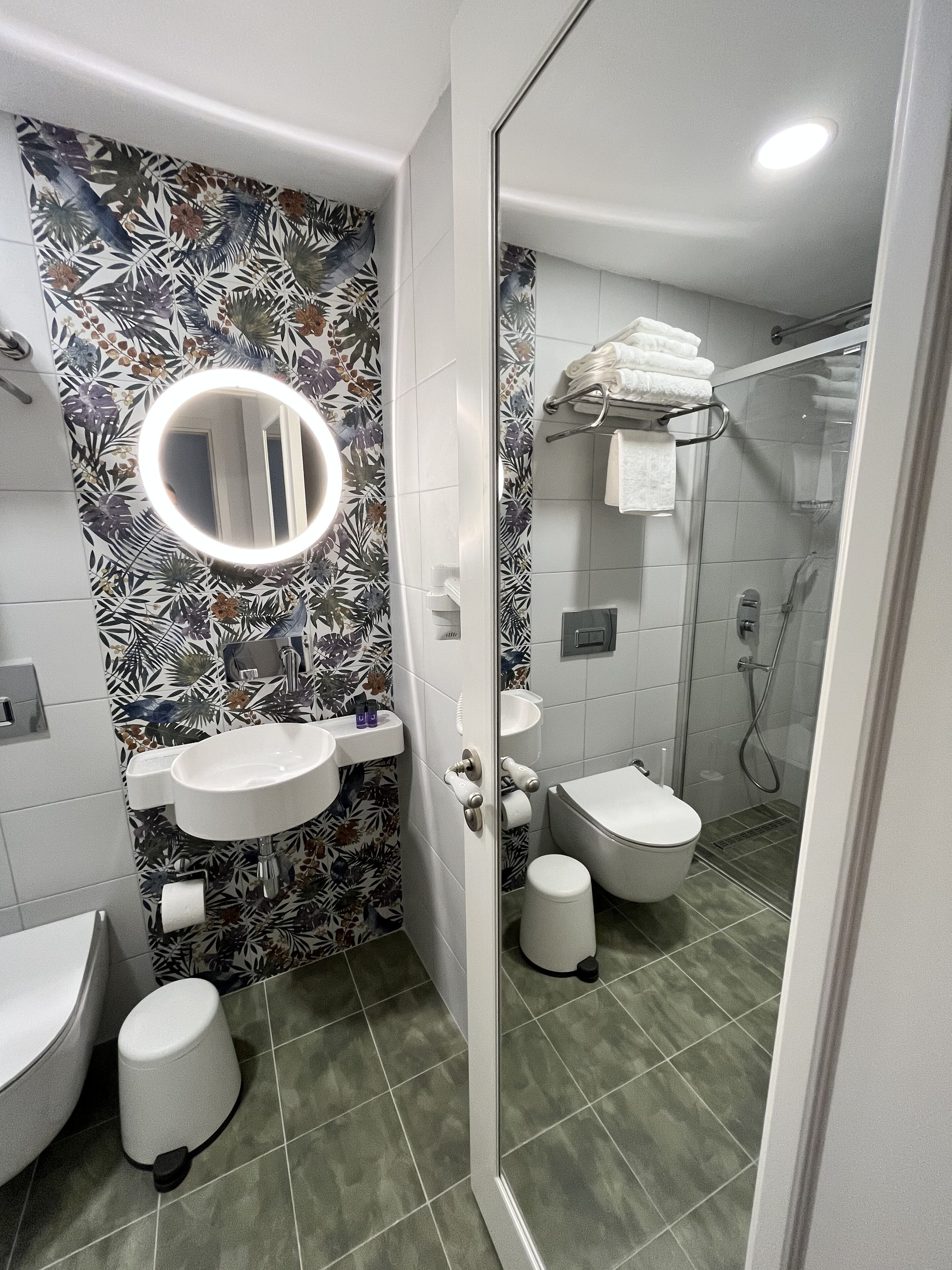 A modern bathroom with a sink, toilet, and shower.